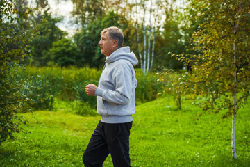 Portrait of an elderly man running in a public park