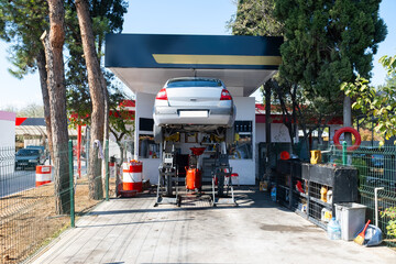 Car lifted by elevator for an oil change at a car service.