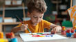 © Kevin - Happy young boy painting with multicolors in creative art class at school