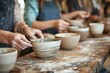 © Boontharika - Close-up of people shaping clay bowls in a pottery class, covered in clay, emphasizing creativity and crafting skills.
