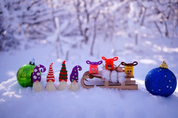 Wall Mural - Dwarf figurines and gifts with smiles made of plasticine on a background of snow. Festive decorations for children.