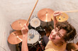 © Westend61 - Cheerful young woman playing drums in basement