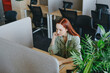 © Westend61 - Redhead businesswoman working at desk in office