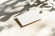© ChaoticMind - A minimalistic image of a blank business card placed on a light surface with artistic shadows, highlighting the texture and elegance of simplicity.