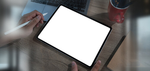 Wall Mural - man using digital tablet with blank white screen mock up on a table at office