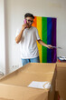© ADDICTIVE STOCK - Trans man coordinating move with colorful pride flag in background