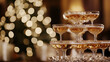 © Tulakarn - Elegant champagne tower with bubbling golden liquid cascading down crystal glasses, soft bokeh lights in background
