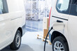 © scharfsinn86 - Electric delivery van with connected charging cable