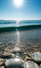 Wall Mural - vertical view of a beautiful ocean shore with sandy beach pebbles and bright sun reflecting on the w
