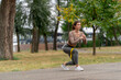 © Guys Who Shoot - on the street in the park in the city center two girls in dark sportswear pumping up their legs and butt with yellow fitness band