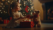 © elenarostunova - A blonde little girl plays with a huge stuffed bear by the Christmas tree and fireplace decorated with stockings for presents.