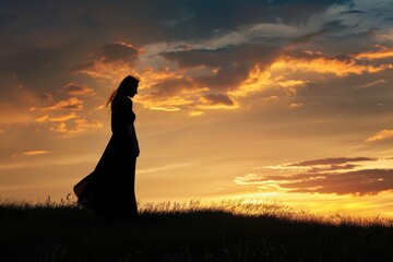 Poster - A woman standing in a field during sunset with a beautiful orange and pink sky