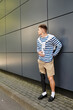 © Bliss - A stylish young man stands confidently against a sleek building, showcasing his prosthetic leg.