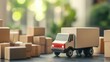 © P.G - Small delivery truck model beside a variety of cardboard boxes, blurred background enhancing the focus on shipping concepts