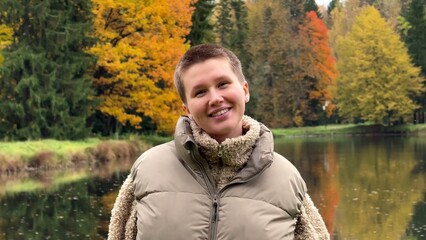 Wall Mural - Happy young woman enjoying autumn weather and walking in the park