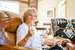 © Louis-Photo - Senior Woman Doing Crossword Puzzle At Home