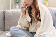 © Pormezz - Unforeseen Discomfort: A Woman Experiences a Sudden Cough, Close-up of a woman coughing and feel chest pain.