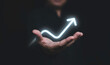 © Dilok - Glowing of up arrow on hand of businessman for business achievement growth of dividend profit concept.