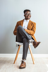 Wall Mural - Confident Young Man Smiling While Sitting in Stylish Attire