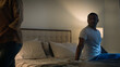 © Yuliia - Sad offended African American woman wife feeling bad about breakup problem relationship trouble with erectile dysfunction man husband touch female calming lady walk away couple family on bed at night