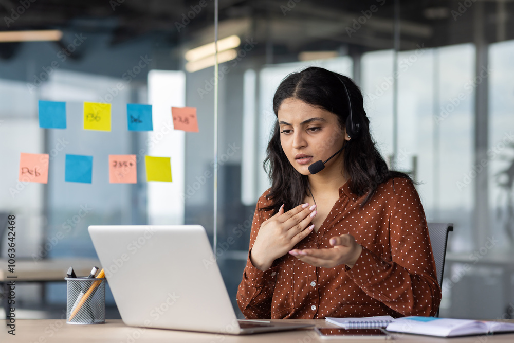 Young Hispanic business woman using laptop and headset during virtual ...