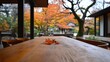 © chic designs - 静かな屋外の雰囲気の中で、素朴なパティオテーブルと色とりどりの葉が織りなす静かな秋の風景