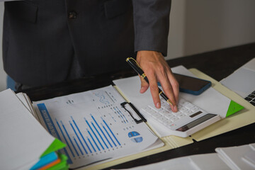 An Asian man works late at his desk papers, determined to meet his deadlines.