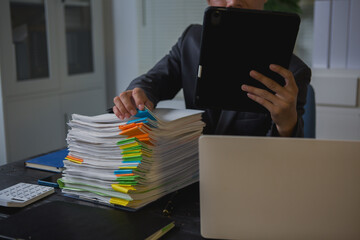 An Asian man works late at his desk papers, determined to meet his deadlines.