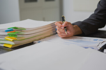 An Asian man works late at his desk papers, determined to meet his deadlines.