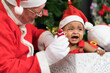 © SOLO PLAYER - Santa Claus calming crying African child while playing together