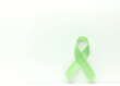 © fotoluigi868 - A green ribbon stands alone on a pristine white canvas creating a simple yet striking visual composition