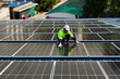 © winnievinzence - Male engineer checking solar cell  or photovoltaic cell by electronic device installed on the roof of the factory. Technician worker repair or inspect the system. Industrial renewable energy concept