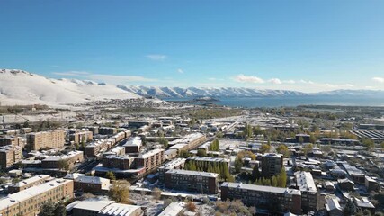 Wall Mural - Aerial panoramic fly over view Sevan town and Lake Sevan. Famous Sevan lake - large, high-altitude lake in eastern Armenia. Winter travel visit destination Armenia concept.