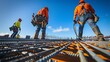 © IMRAN - Construction workers using specialized tools to install new roofing panels, fall protection devices in place, working efficiently under a clear blue sky.