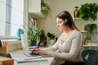© Valerii Honcharuk - Young woman student with headphones typing on laptop sitting at desk at home