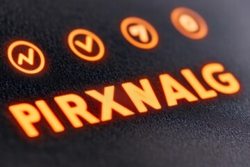 Canvas Print - Close up of a glowing orange PIRXNALG text with checkmark and number symbols.