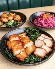 Canvas Print - Crispy pork belly with green leafy vegetables and pickled cabbage salad on black plates.