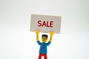 Wall Mural - toy man holding a sign with the text (Sale)