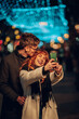© Zamrznuti tonovi - Loving couple taking selfies, hugging and kissing on street on new year