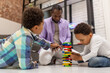 © zinkevych - African american bearded man looking involved while playing with his sons