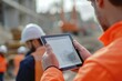 © Nognapas - Everyone needs to be on the same page. Shot of a group of architects using a digital tablet at a building site.