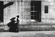 © Konstiantyn Zapylaie - Solitary figure walking on sunlit street with dramatic shadow in black and white