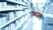 © Oksana - A person in a white coat holds a clipboard, standing in front of shelves with boxes. Concept of healthcare and organization.