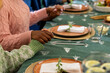 © WavebreakMediaMicro - Christmas time, multiracial friends holding hands at festive dinner table, at home