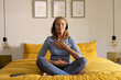 © Wavebreak Media - senior woman meditating on bed with headphones, enjoying peaceful moment, at home