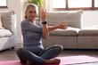 © Wavebreak Media - senior woman practicing yoga on mat at home, stretching and smiling peacefully