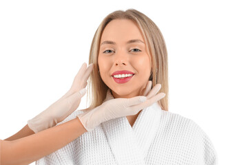 Canvas Print - Beautician examining face of young woman on white background