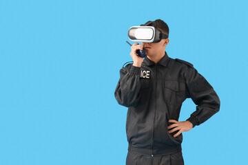 Male police officer in VR glasses with two-way radio on blue background