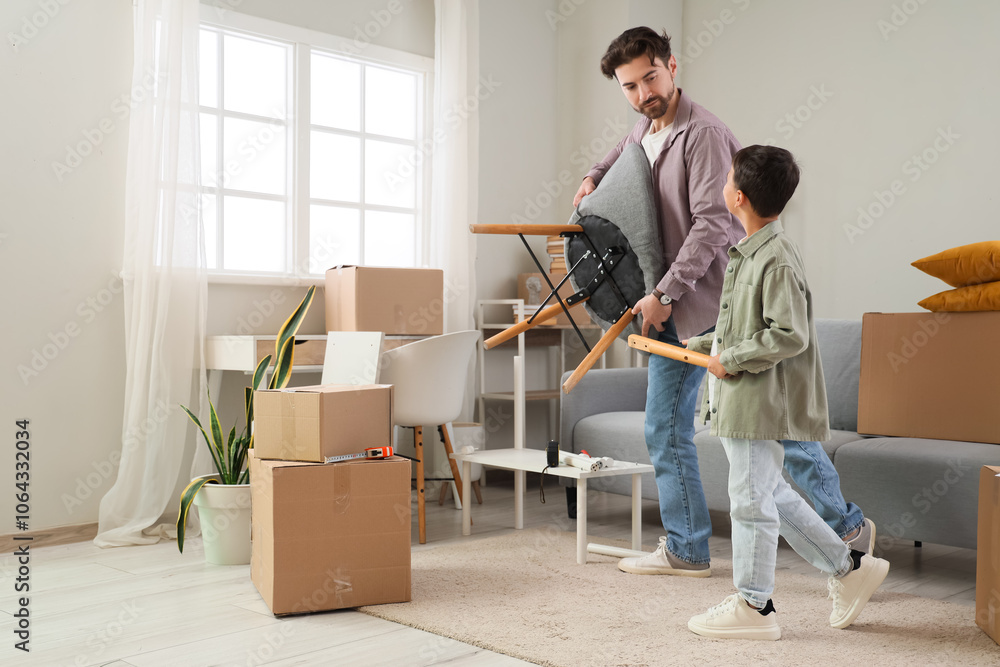 Father with his little son assembling armchair in room on moving day