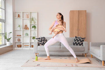 Wall Mural - Sporty young woman with her little baby doing yoga at home